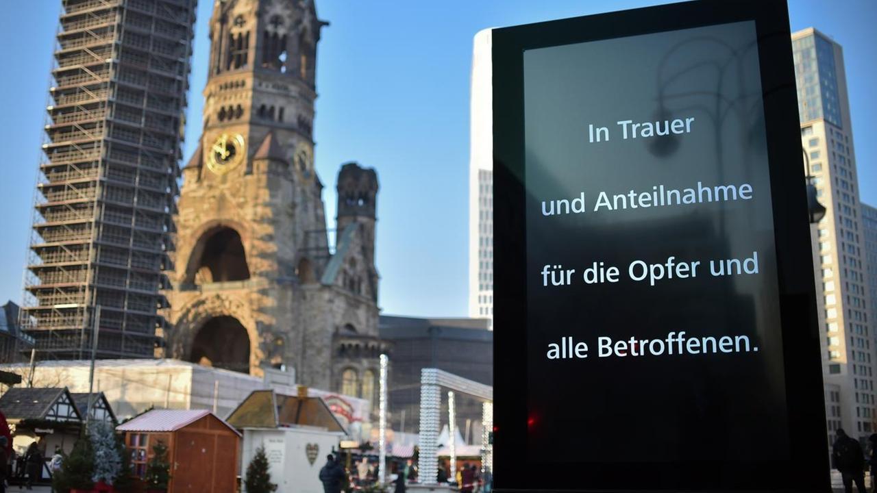 Eine Werbefläche neben der Berliner Gedächtniskirche erinnert an die Opfer des Anschlags auf den Weihnachtsmarkt.