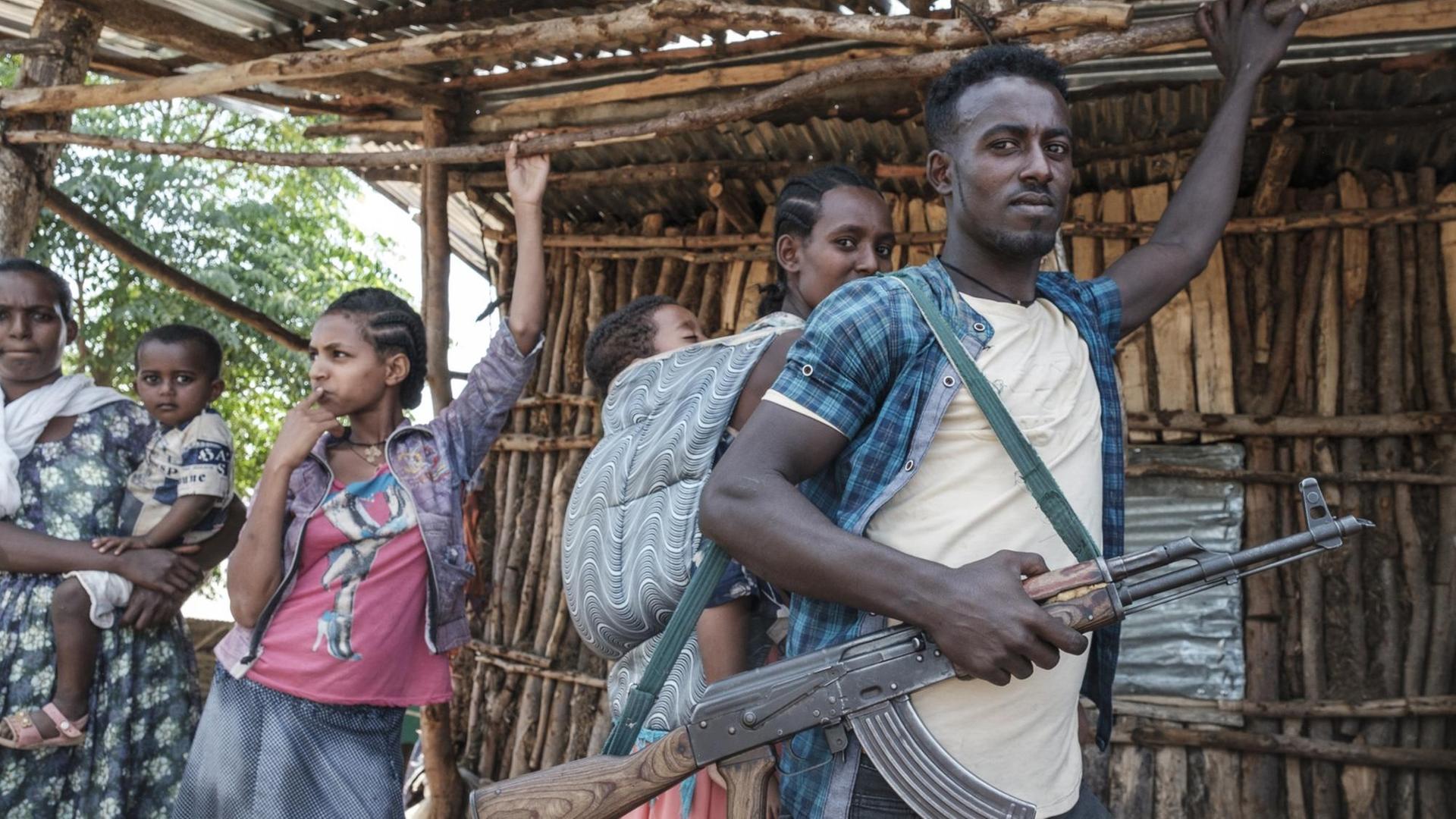 Eine Gruppe Menschen in Äthiopien. Ein Mann hat ein Gewehr in der Hand.