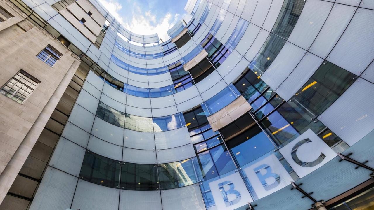 Zentrale der BBC in London. Das Gebäude mit Glasfassade aus der Froschperspektive.