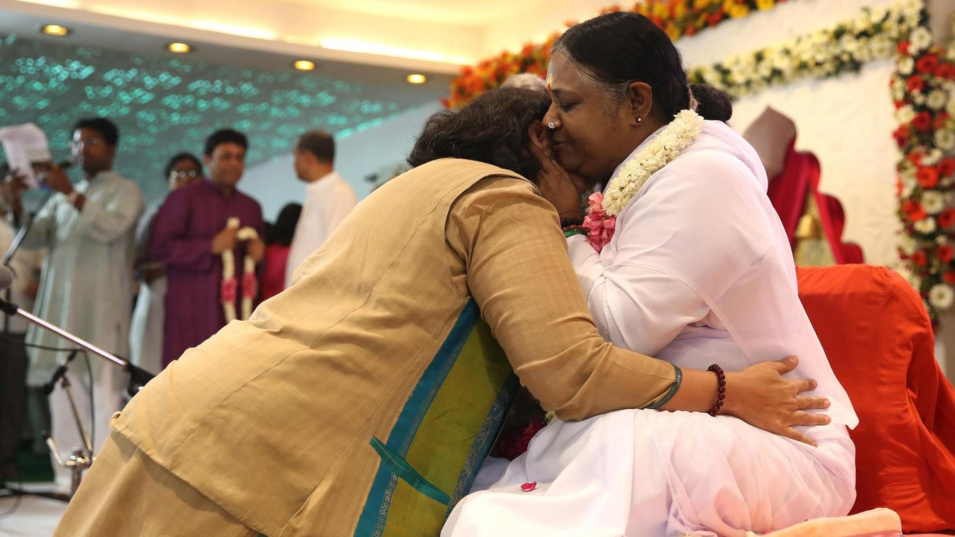 Guru Sri Mata Amritanandamayi Devi - auch Amma genannt - umarmt eine Anhängerin während einer Veranstaltung am 04. April 2016 in Neu-Dehli, Indien.