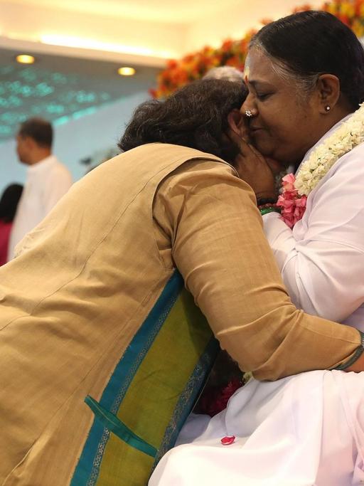Guru Sri Mata Amritanandamayi Devi - auch Amma genannt - umarmt eine Anhängerin während einer Veranstaltung am 04. April 2016 in Neu-Dehli, Indien.