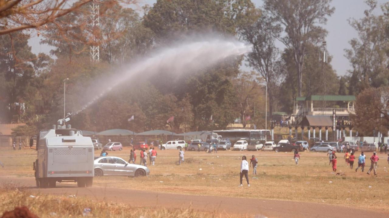 Die Polizei in Simbabwe treibt Demonstranten mit Wasserwerfern auseinander.