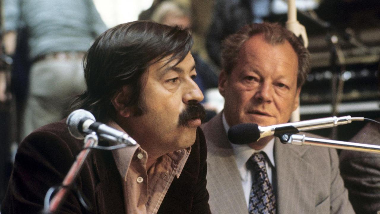 Der SPD Vorsitzende Willy Brandt (r) und der Schriftsteller Günter Grass (l) bei einer Wahlveranstaltung 1976 im Kulturzentrum Fabrik in Hamburg.