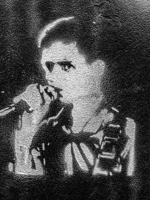 Streetart in London: Schablonenbild (Stencil) von Ian Curtis, dem verstorbenen Frontman der Band Joy Division an einer Hauswand in London. Darunter steht die Zeile "love will tear us apart".