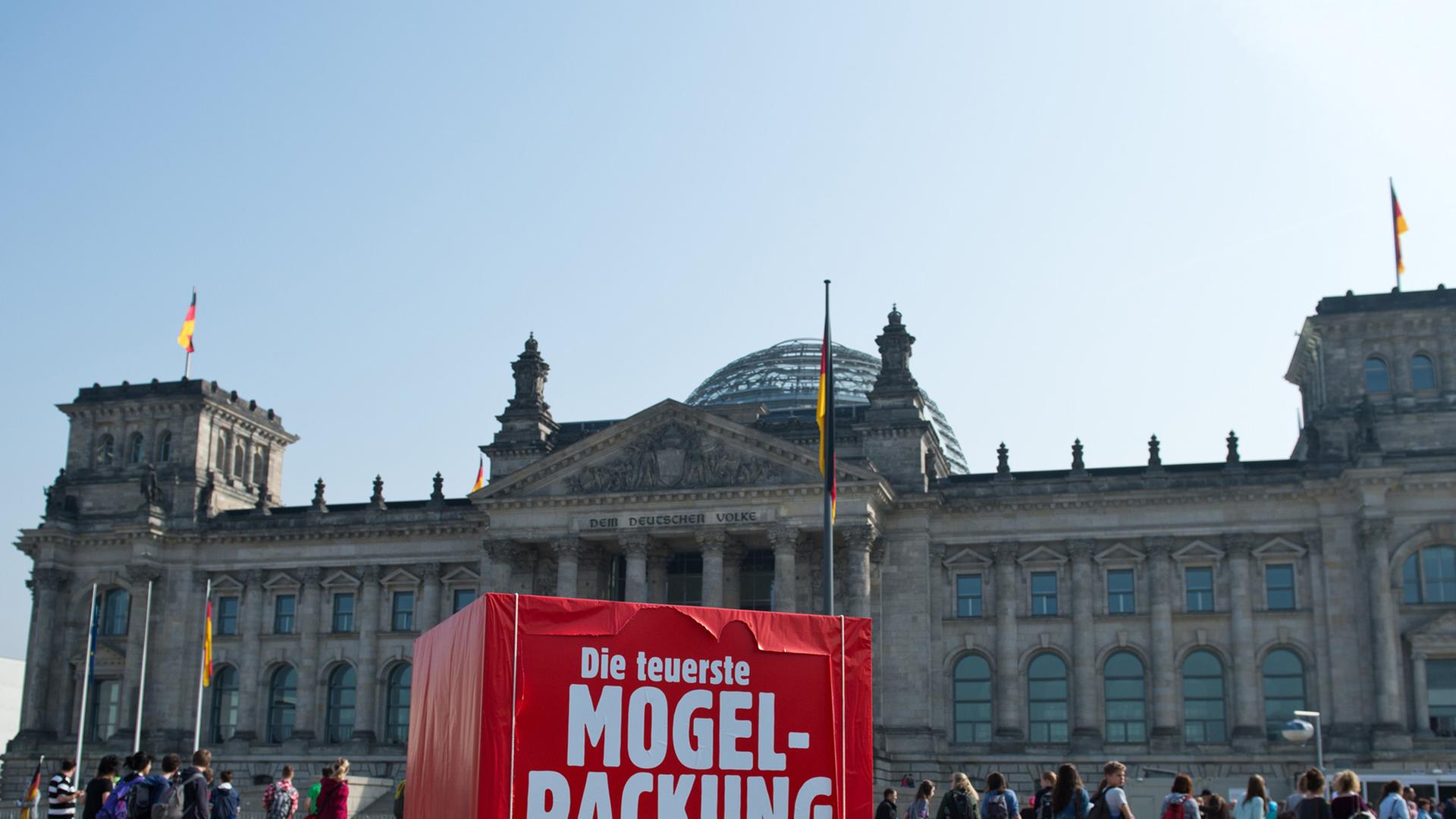Ein rotes Riesen-Paket als Protest der Partei Bündnis 90/Die Grünen mit der Aufschrift "Die teuerste Mogelpackung aller Zeiten" steht vor dem Reichstagsgebäude in Berlin.