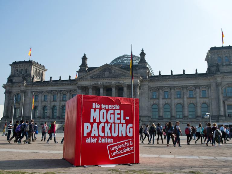 Ein rotes Riesen-Paket als Protest der Partei Bündnis 90/Die Grünen mit der Aufschrift "Die teuerste Mogelpackung aller Zeiten" steht vor dem Reichstagsgebäude in Berlin.
