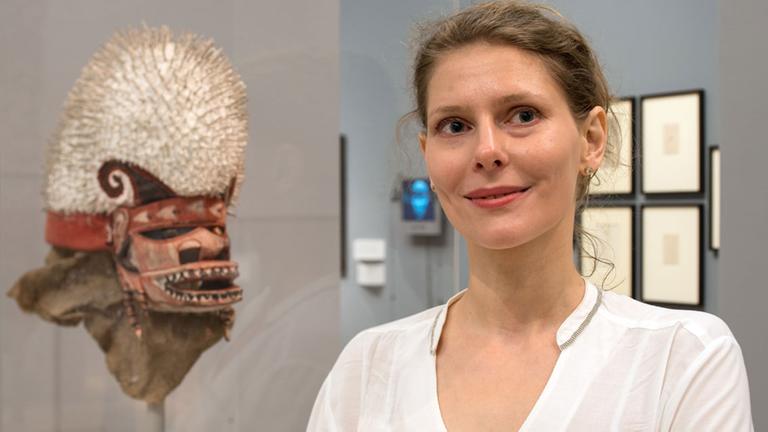 Der blinde Fleck, Bremer Kunsthalle, Julia Binter, steht am neben einer Tatanua-Maske eines unbekannten Künstlers aus Neuirland.