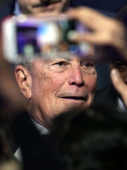 Der US-Präsidentschaftsbewerber Bloomberg in einer Menschenmenge; mit einem Smartphone wird ein Foto von ihm gemacht.