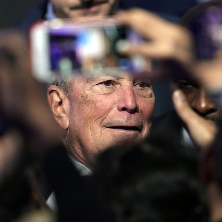 Der US-Präsidentschaftsbewerber Bloomberg in einer Menschenmenge; mit einem Smartphone wird ein Foto von ihm gemacht.