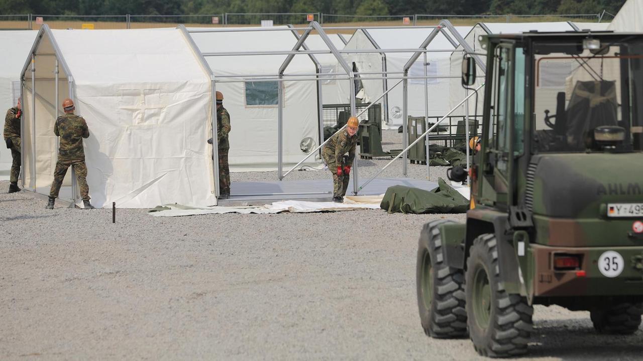 Soldaten der Bundeswehr bauen auf dem Geländer der Zentralen Anlaufstelle für Asylbewerber in Halberstadtt Zelte auf.