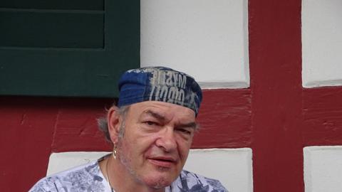 Walter Nowak steht vor einem Fachwerkhaus.