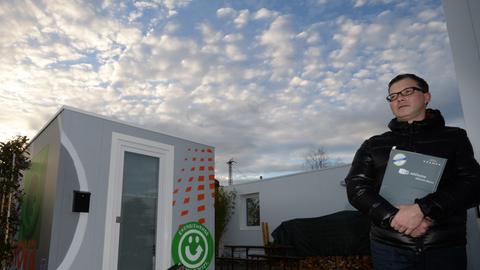 Marketingleiter Frank Gremmelspacher posiert am 16.12.2013 in Freiburg (Baden-Württemberg) vor zwei Wohncontainer für Studenten. In der Studentenstadt testen vier Studierende neuen Wohnraum in Form von Containern.