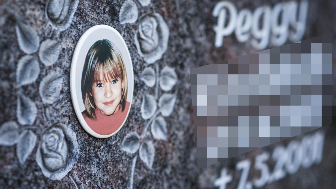 Auf dem dunklen Gedenkstein ist ein kleines Bild Peggys, umrahmt von eingemeißelten Blumen.