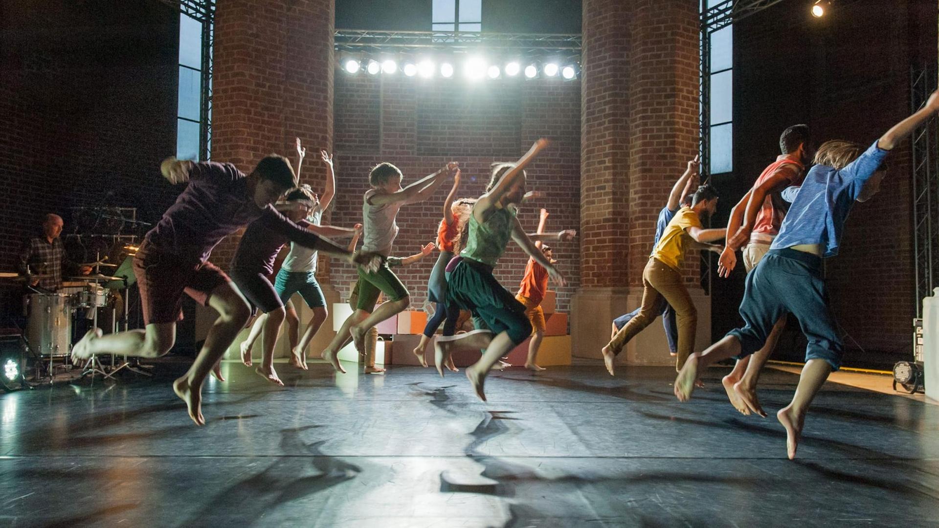 Szene aus "Das Fremde - so nah" am Anhaltischen Theater in Dessau. Die Darsteller springen bei einer Tanzperformance gleichzeitig in die Luft.