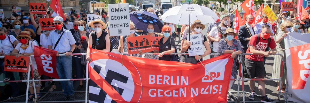 Ein Banner "Berlin gegen Nazis" und Plakate "Omas gegen rechts" bei einer Gegendemonstration zur Demonstration gegen die Corona-Beschränkungen auf der Leipziger Straße