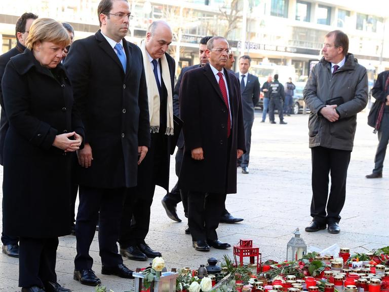 Bundeskanzlerin Angela Merkel (2.v.l, gedenkt mit Tunesiens Ministerpräsident Youssef Chahed (3.v.l)am 14.02.2017 in Berlin am Breitscheidplatz der Opfer des Anschlags vom 19. Dezember 2016.