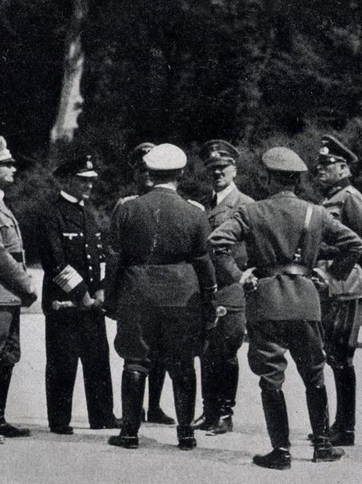 Hitler mit Offizieren im Jahr 1940 im Walv von Compiègne, in dem im Juni desselben Jahres der Waffenstillstand zwischen Frankreich und Deutschland geschlossen wurde, Schwarz-weiß-Aufnahme.
