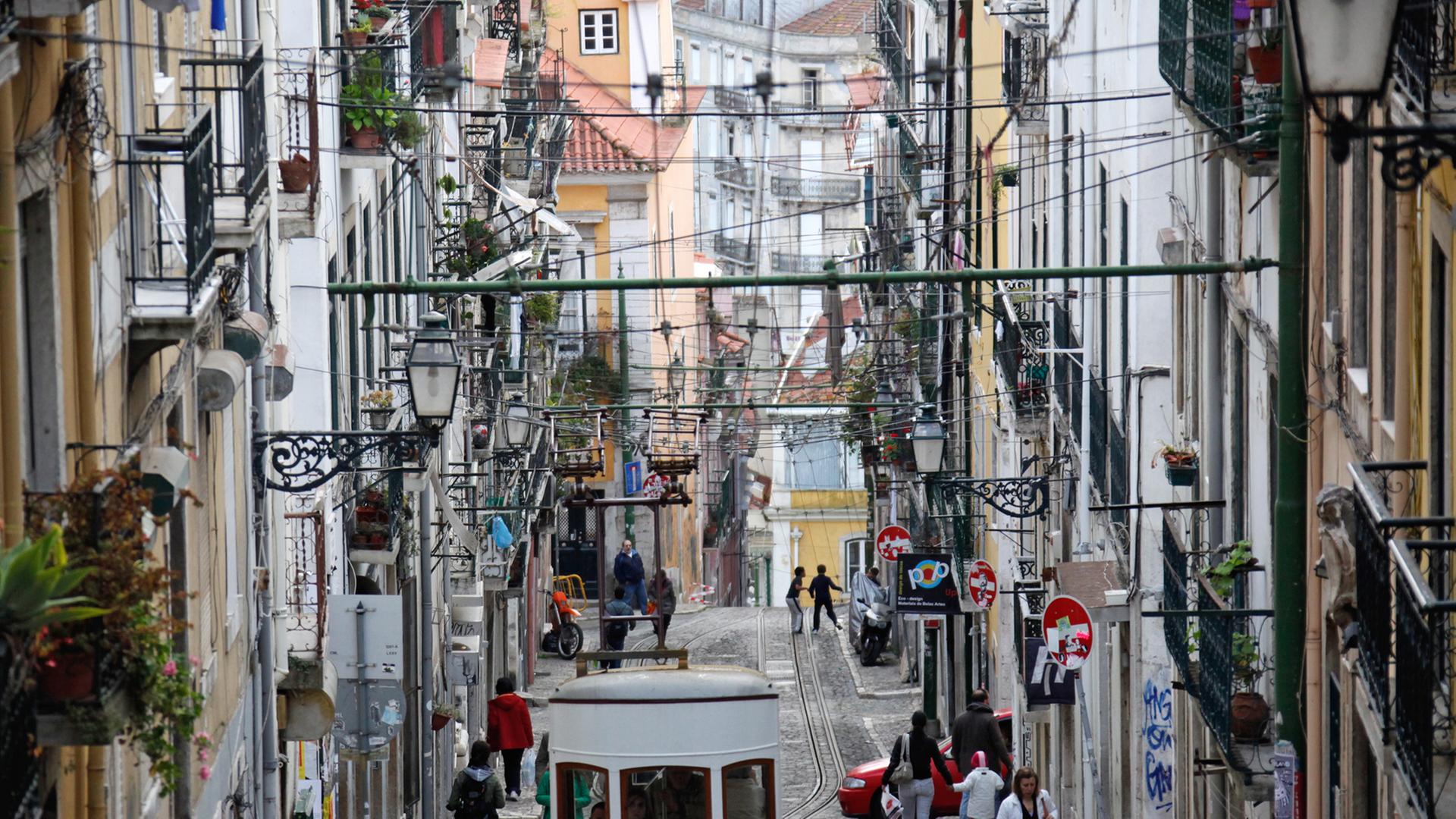 Die Standseilbahn "Ascensor da Bica" fährt durch eine Gasse in Lissabon.
