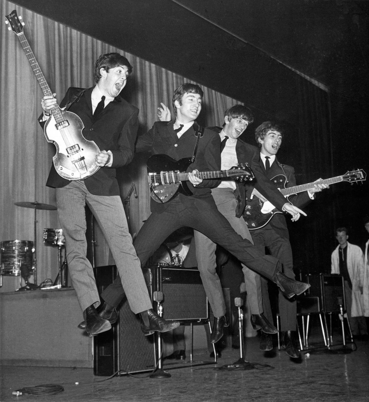 The Beatles: Paul McCartney, John Lennon, Ringo Starr und George Harrison bei einem Luftsprung auf der Bühne des Prince of Wales Theatre in London.