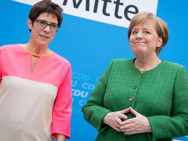 Bundeskanzlerin Angela Merkel (CDU) und Annegret Kramp-Karrenbauer, Saarlands Ministerpräsidentin (l, CDU) stehen auf einer Pressekonferenz im Konrad-Adenauer-Haus zusammen.