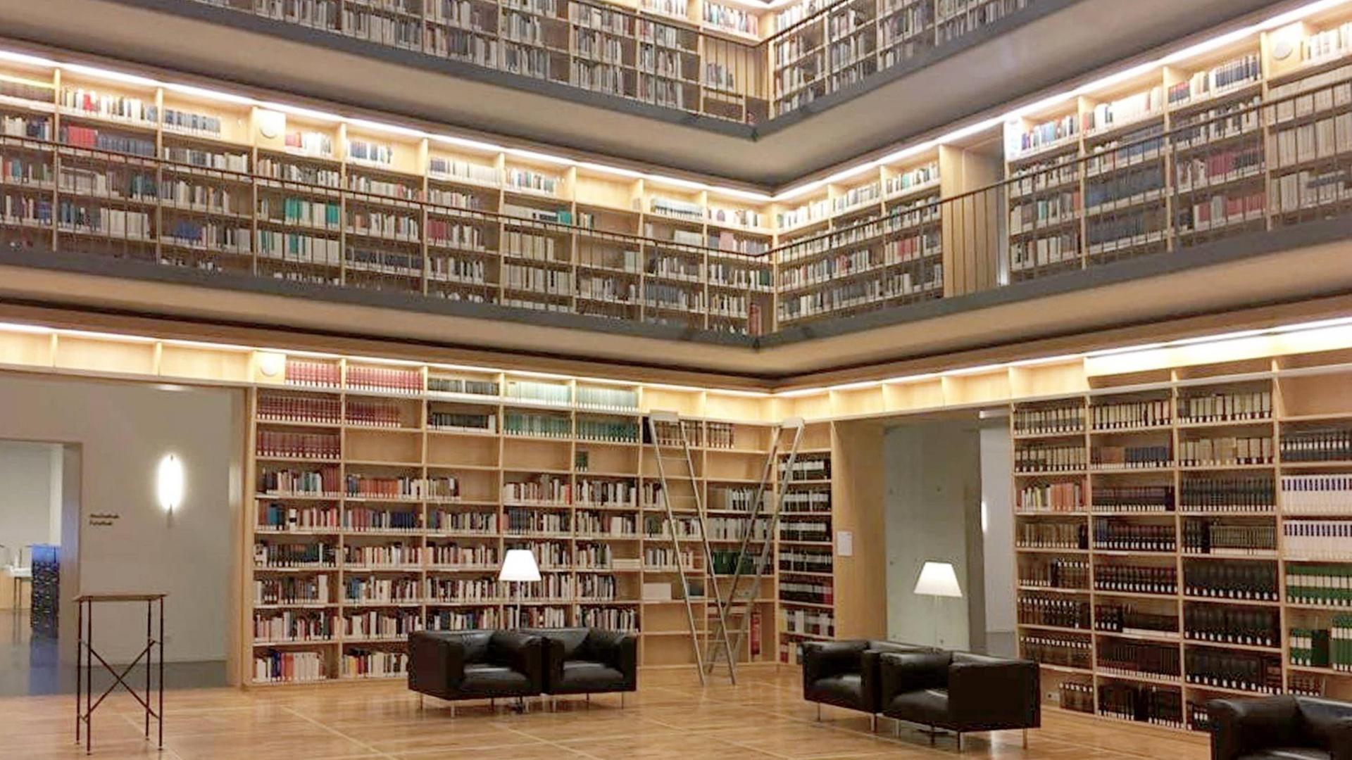 Das Bild zeigt die Stadtbücherei von Weimar - an den Wänden stehen hohe Regale über mehrere Etagen mit unzähligen Büchern.