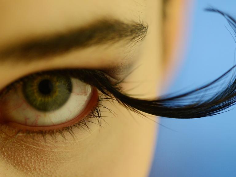 Das Auge einer Frau mit überlangen künstlichen Wimpern
