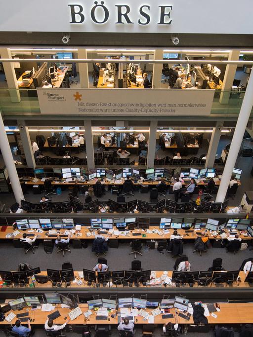 Börsenhändler sitzen in der Börse Stuttgart vor ihren Monitoren.