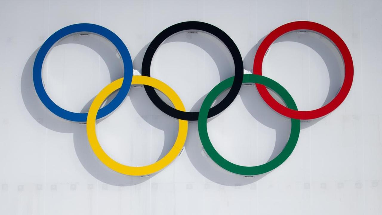 Die Olympischen Ringe: 5 Ringe sind ineinander verschlungen. Drei sind in der pberen Reihe. Zwei sind in der unteren Reihe. Jeder der Ringe hat eine andere Farbe. Die Olympischen Ringe: 5 Ringe sind ineinander verschlungen. Drei sind in der pberen Reihe. Zwei sind in der unteren Reihe. Jeder der Ringe hat eine andere Farbe.