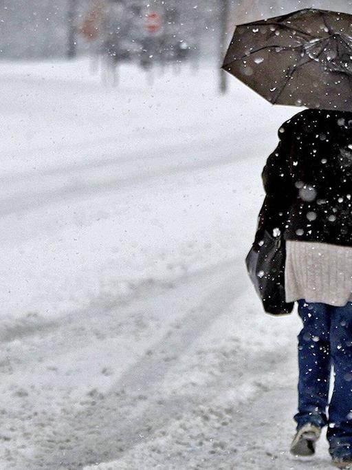 Eine Frau läuft durch einen Schneesturm. Eine Frau läuft durch einen Schneesturm.