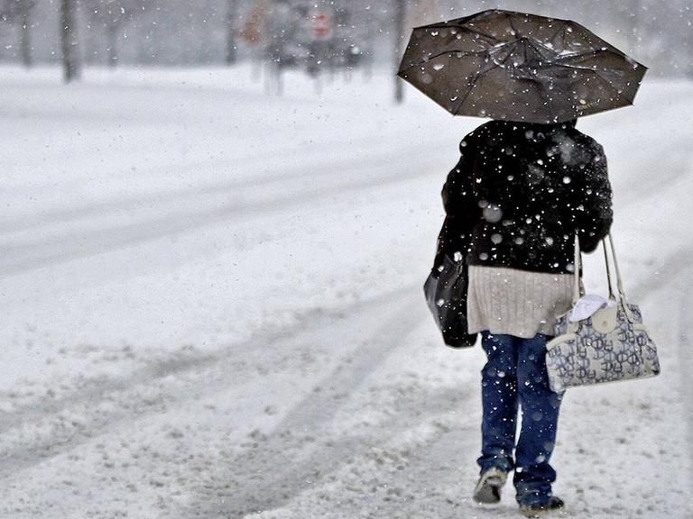 Eine Frau läuft durch einen Schneesturm. Eine Frau läuft durch einen Schneesturm.