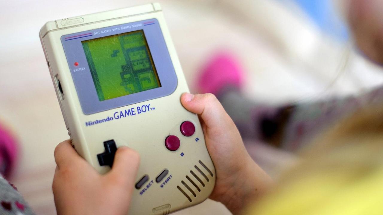 Ein Kind spielt auf einem originalen Game Boy das Spiel Tetris.