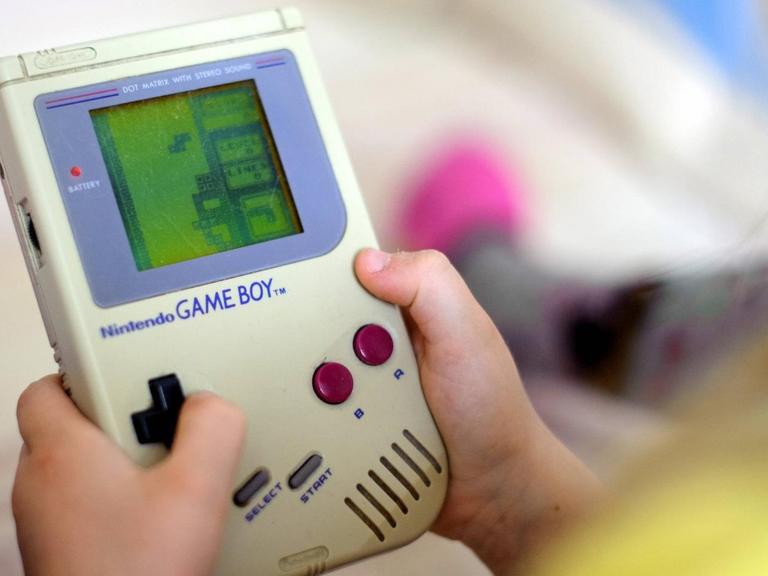Ein Kind spielt auf einem originalen Game Boy das Spiel Tetris.