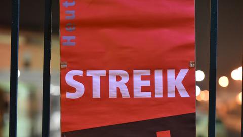 Ein Verdi-Plakat mit dem Text "Streik" hängt an einem Metallzaun.