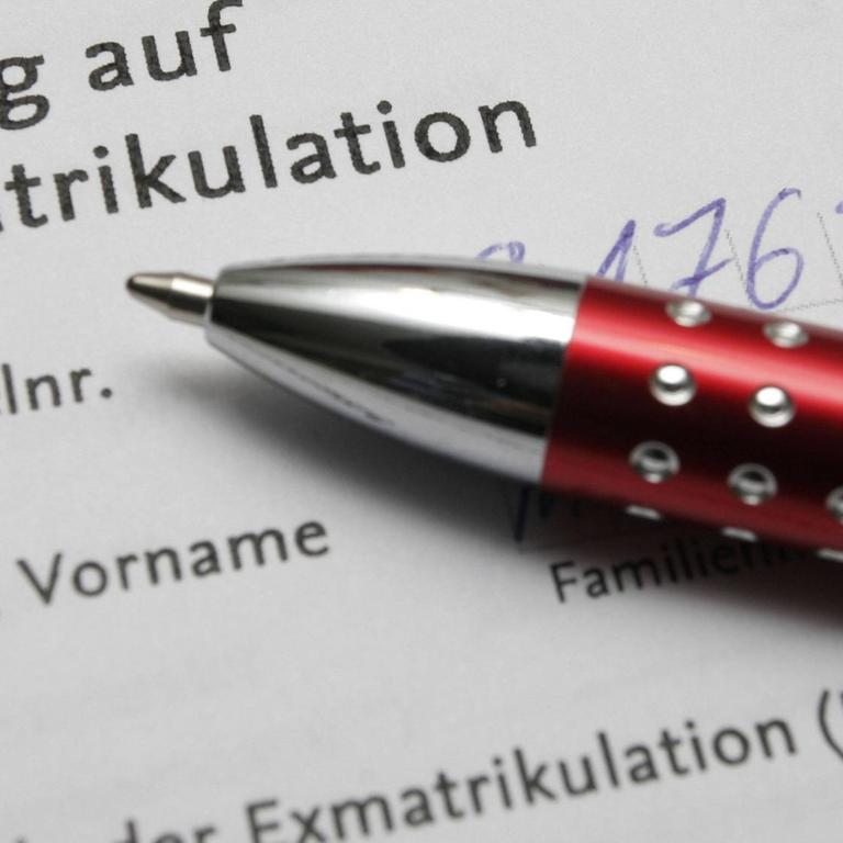 Ein weißes Dokument mit aufgedruckter Schrift. Zu lesen ist: "Antrag auf Exmatrikulation". Auf dem Blatt Papier liegt ein rot-silberner Kugelschreiber.