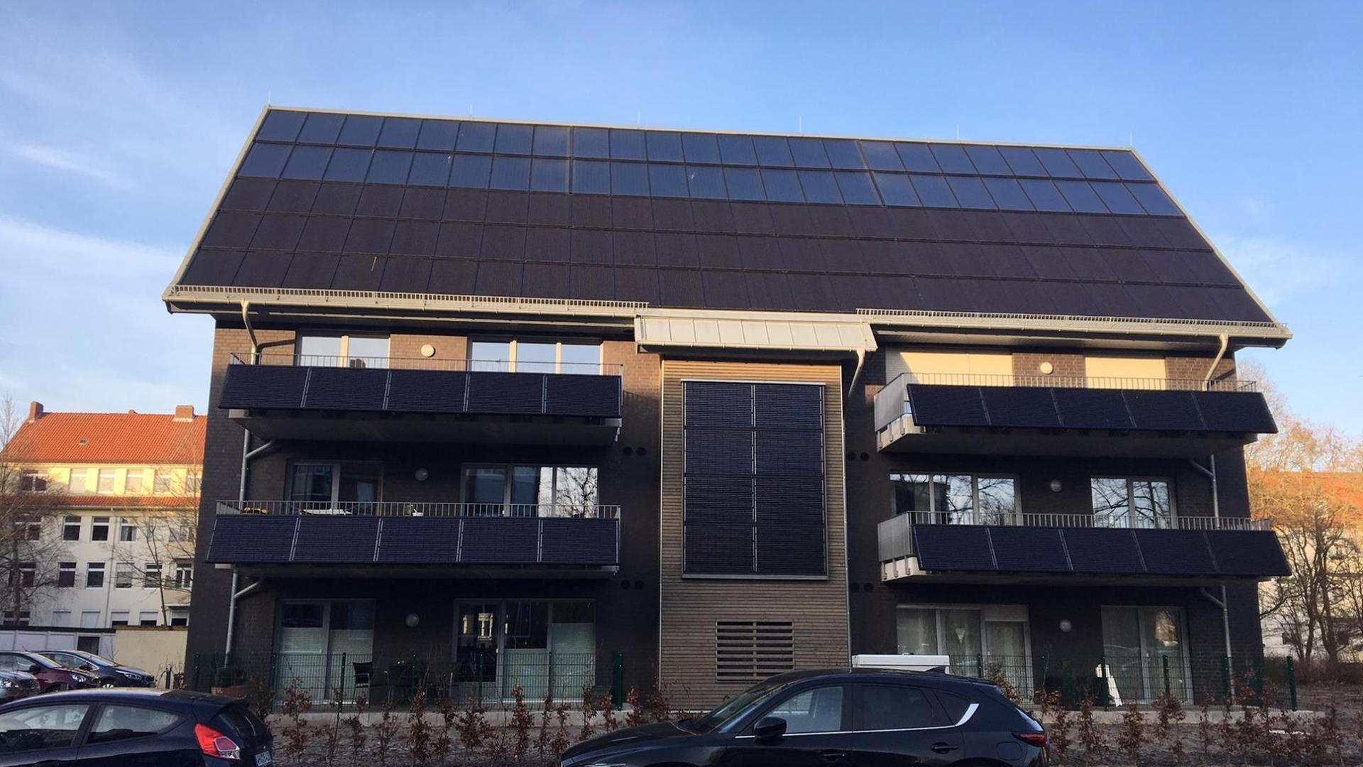 Ein Mehrfamilienhaus mit Solaranlagen auf dem Dach