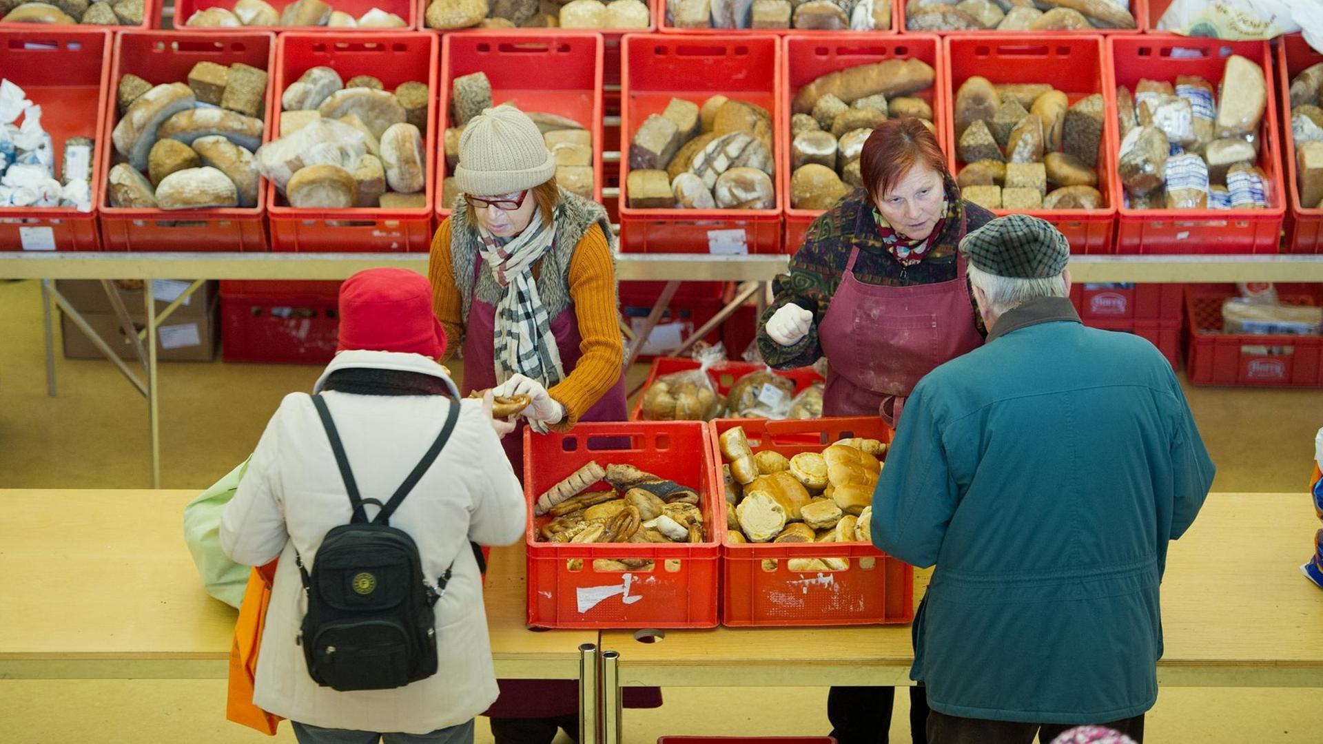 Brot verteilen ehrenamtliche Helferinnen in Wiesbaden (Hessen) am 13.12.2012 in der Tafel der Stephanusgemeinde an Bedürftige. Zur Klientel der ausschliesslich spendenfinanzierten Tafel gehören unter anderem Rentner, Arbeitslose, Alleinerziehende und Geringverdiener. Foto: Boris Roessler dpa (Zu dpa-lhe Blickpunkt "Wenn es nicht reicht: Tafeln in Hessen haben grossen Zulauf" vom 16.12.2012) | Verwendung weltweit