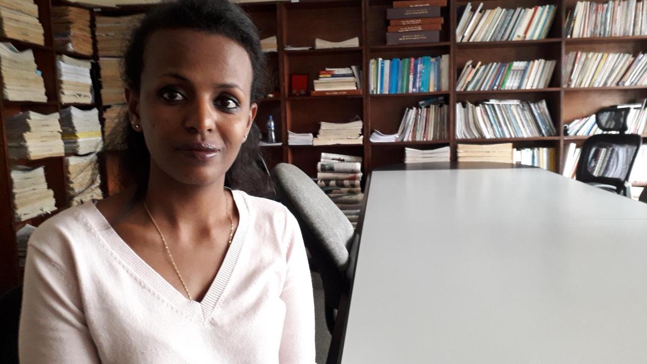 Die Journalistin Fasika Tadesse sitzt an einem langen Konferenztisch und blickt in die Kamera.