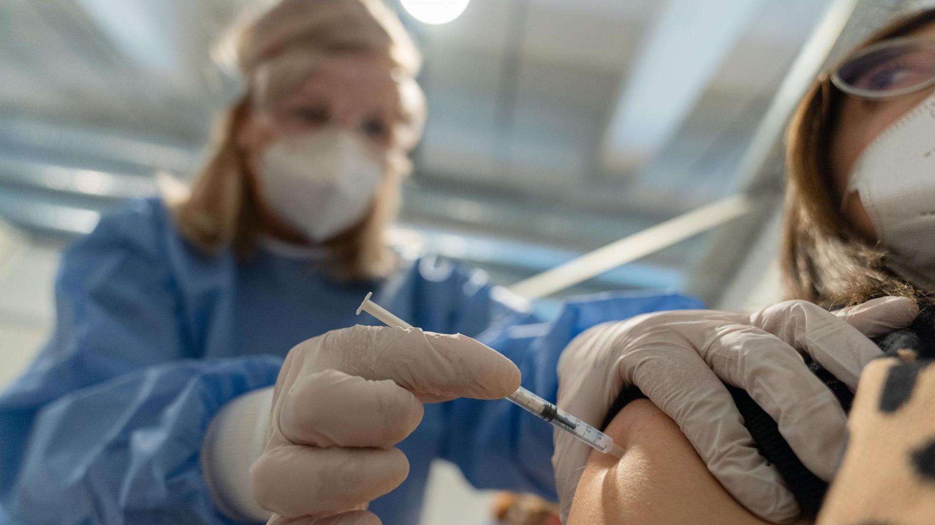 Eine medizinische Fachangestellte setzt bei einem Probedurchlauf im Impfzentrum Bamberg bei einer Dame zur Impfung an. In der Spritze befindet sich kein Impfstoff. Im sich noch im Aufbau befindlichen Impfzentrum in der Bamberger Brose Arena wurden bereits Probeabläufe durchgeplant.