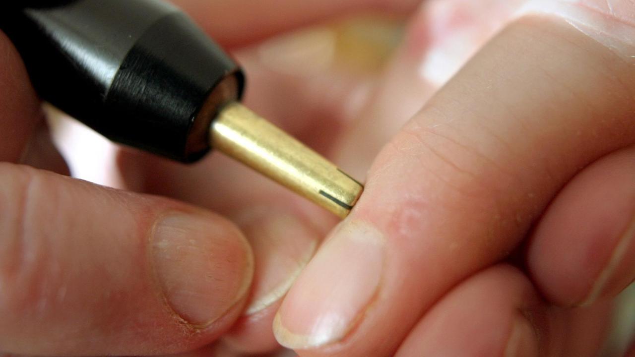 Ein metallisches Messgerät wird an einen Finger gedrückt.
