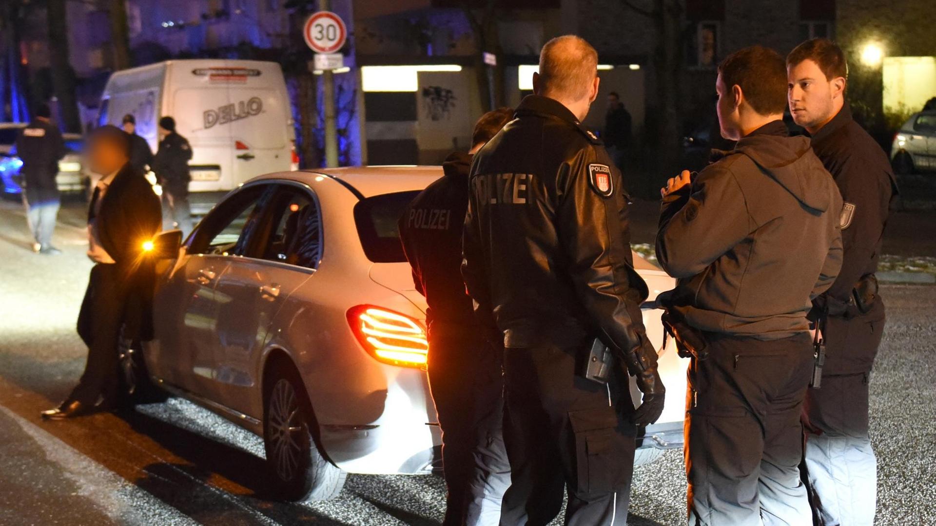 19.01.2019, Hamburg: Polizisten kontrollieren am frühen Abend im Stadtteil Mümmelmannsberg ein Auto.