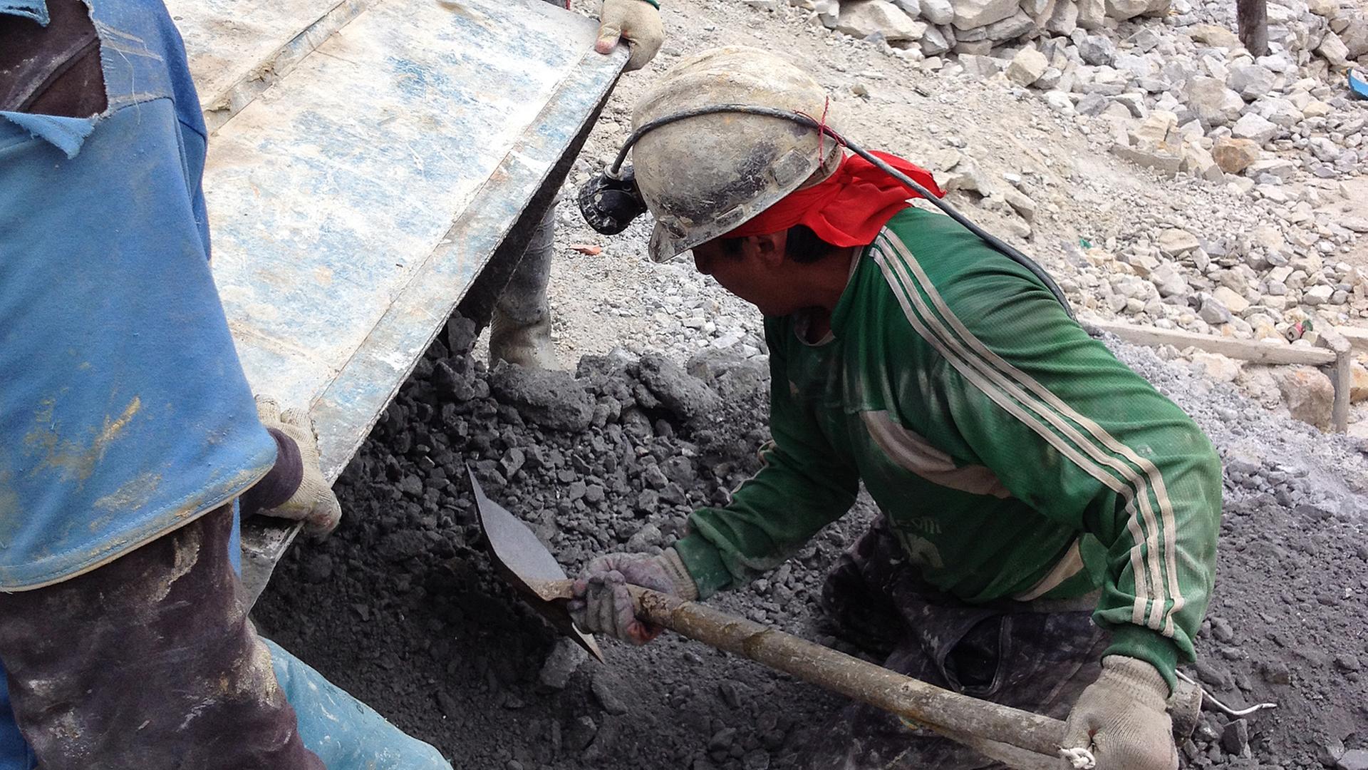 Kinderarbeiter bringen die Mineralien und das Gestein nach draußen.