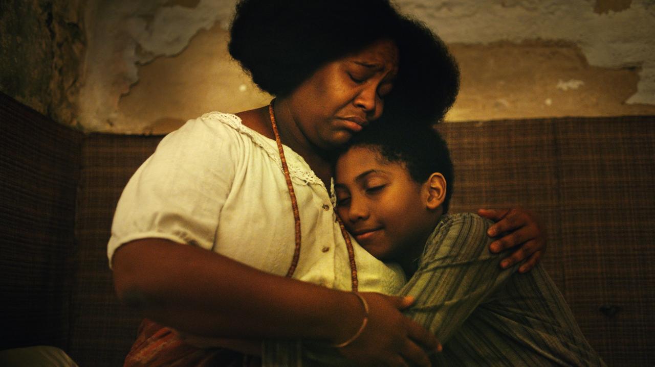 Filmstill aus Todos os mortos: Eine Frau hält ein Kind in ihren Armen.