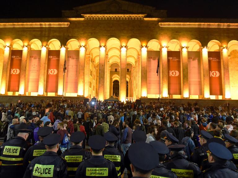 Protest gegen Drogenrazzien in zwei populären Clubs in der georgischen Hauptstadt Tiflis am späten Abend des 13.05.2018: zahlreiche junge Menschen und einige Polizisten stehen vor dem Parlamentsgebäude.