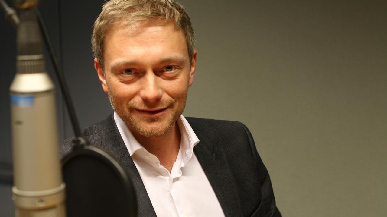 Christian Lindner im Hörfunkstudio vor dem Mikrophon.