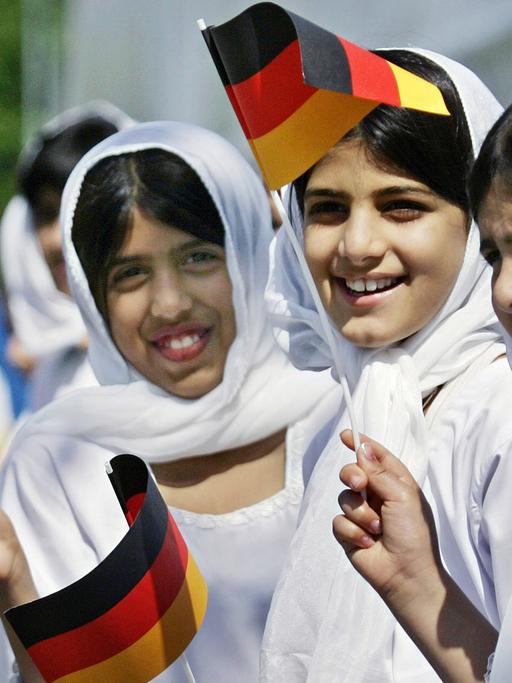 Muslimische Mädchen schwenken auf der Jahresversammlung der moslemischen Reformgemeinde Ahmadiyya auf dem Maimarktgelände in Mannheim deutsche Fahnen.