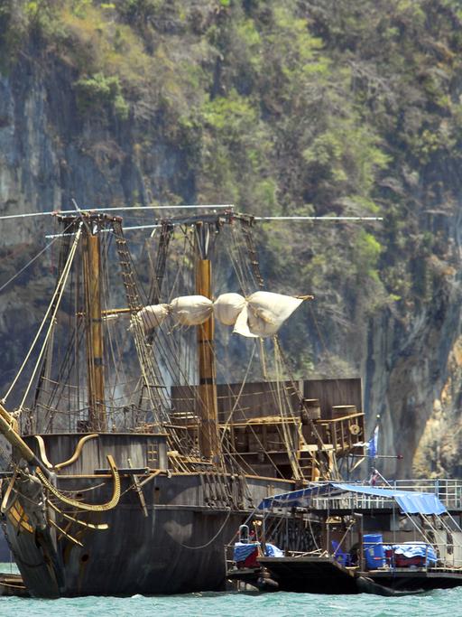 Ein historisches Segelschiff vor Inselpanorama.