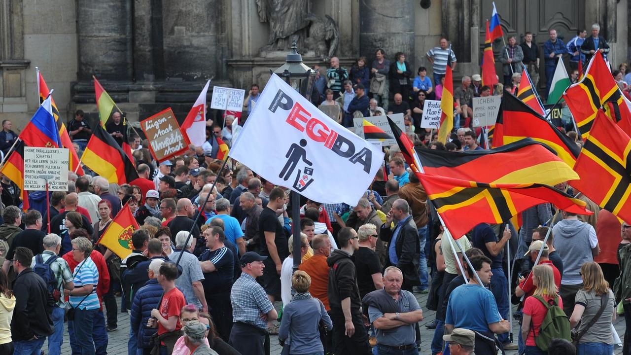 Einige hundert Anhänger des islamkritischen Bündnisses Pegida treffen sich am 04.05.2015 in Dresden (Sachsen) zu einer Kundgebung und halten Deutschland-Fahnen hoch. 