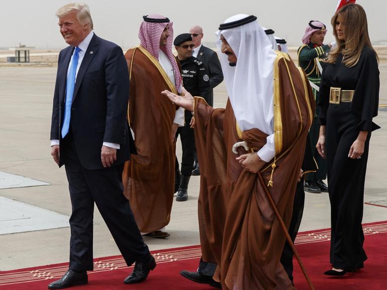 Salman führt die Trumps auf dem Rollfeld des Flughafens über einen roten Teppich
