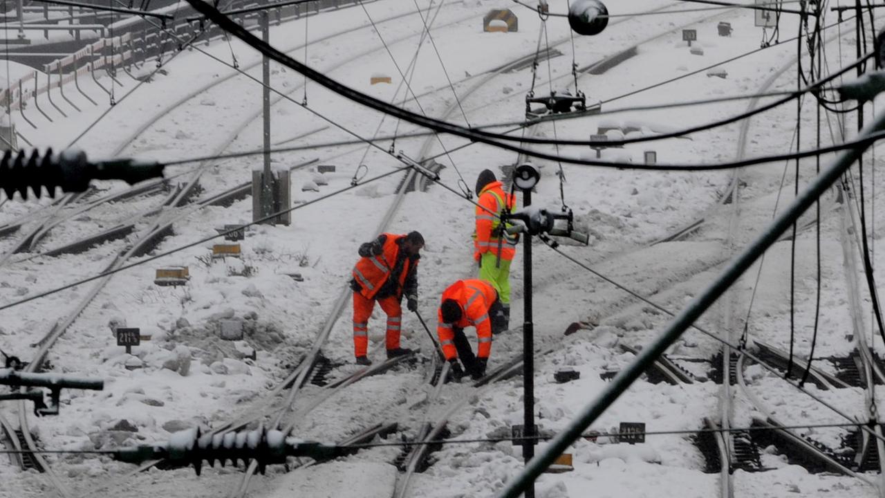 Gleisarbeiter befreien am Dienstag (28.12.2010) in Hamburg kurz vor dem Hauptbahnhof Weichen von Schnee und Eis. Etwa 50 Reisende eines ICE haben in der Nacht zum Dienstag nach einem Stromausfall kurz vor dem Hamburger Hauptbahnhof zwei Stunden festgesess