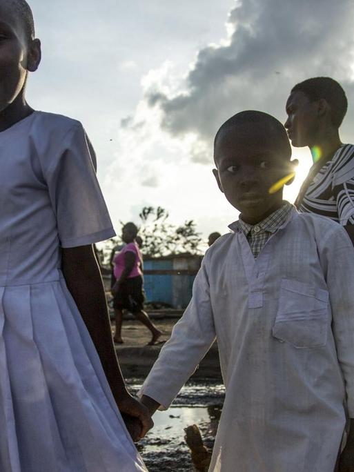Kinder laufen über eine aufgeweichte Straße im Slum von Mathare in Nairobi /Kenia